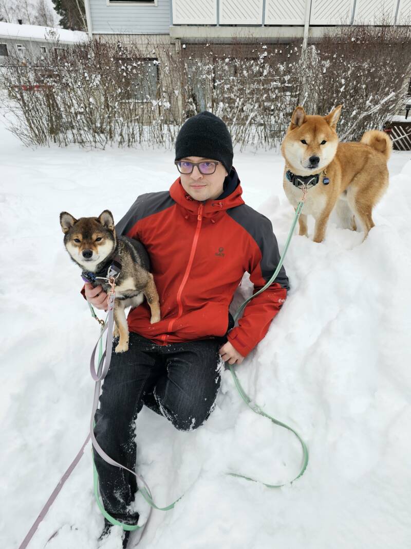 Niila Jouppila lumisessa talvimaisemassa yhdessä kahden shiba-koiransa kanssa